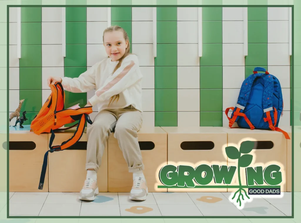 An elementary student sits on a bench against a wall and opens her orange backpack