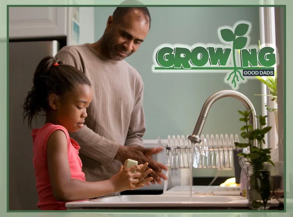 A dad and his young daughter stand at the kitchen sink together to wash their hands with a bar of soap