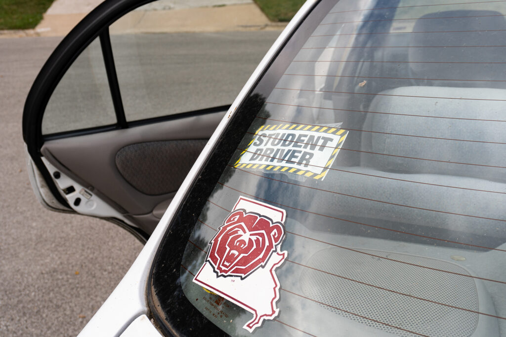 The back window of a car with two stickers: a Missouri State University window decal and a Student Driver sticker.