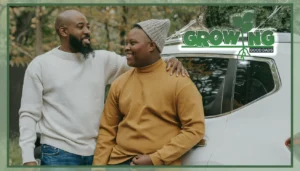 A father wraps his arm around his son. The two smile at each other