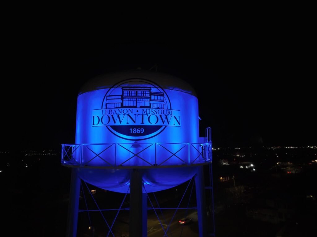 Blue lights shine from below onto the Lebanon water tower at night.