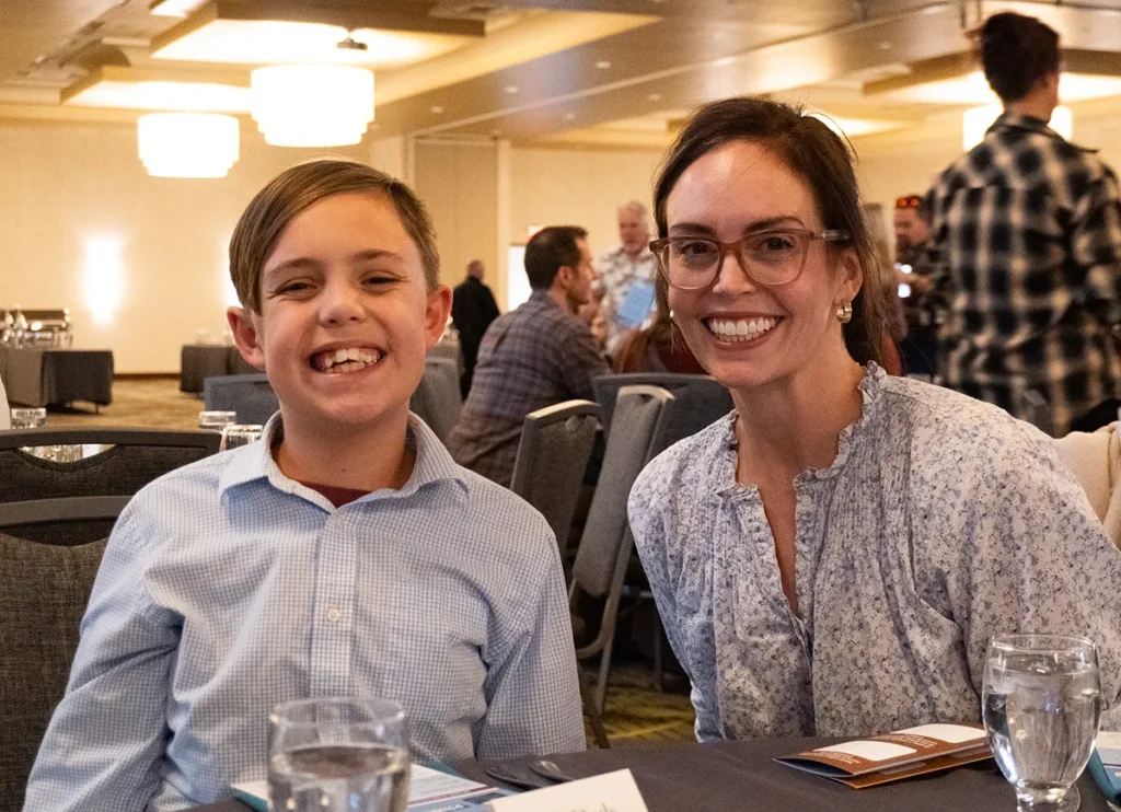 A happy mother and son sitting at a table.