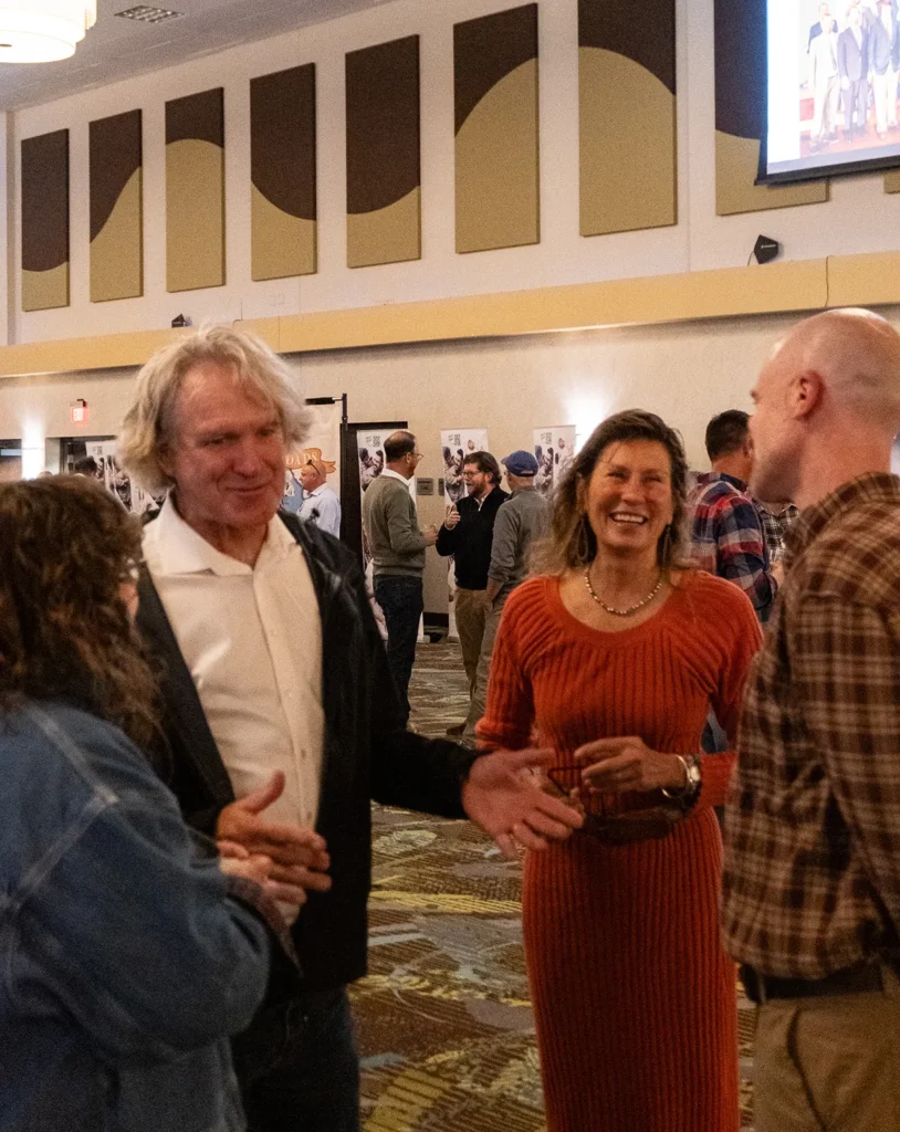 A group of guests stand in a circle and laugh.