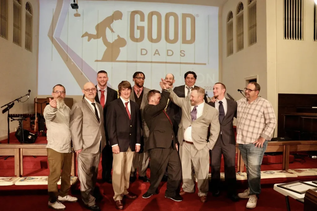 Joplin Dads in suits smile for a group photo during Good Dads Graduation in November 2023.