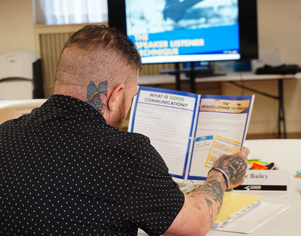 A man looking at his booklet during the unit on communication