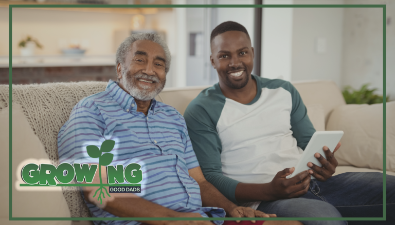 An older dad sits on a couch next to his adult son