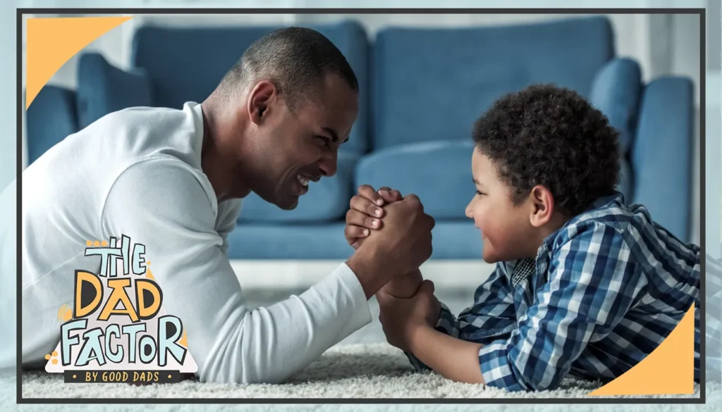 The Dad Factor: A Father and son arm wrestle on the floor in front of a couch
