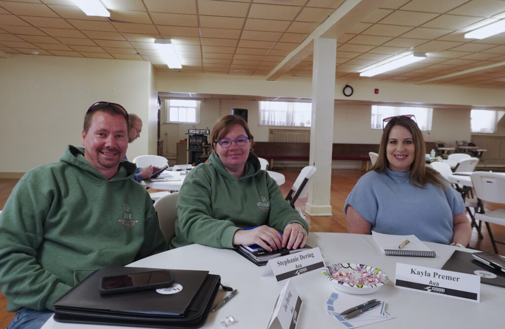 Three Good Dads Ava chapter leaders smile for a group photo while sitting at their table.