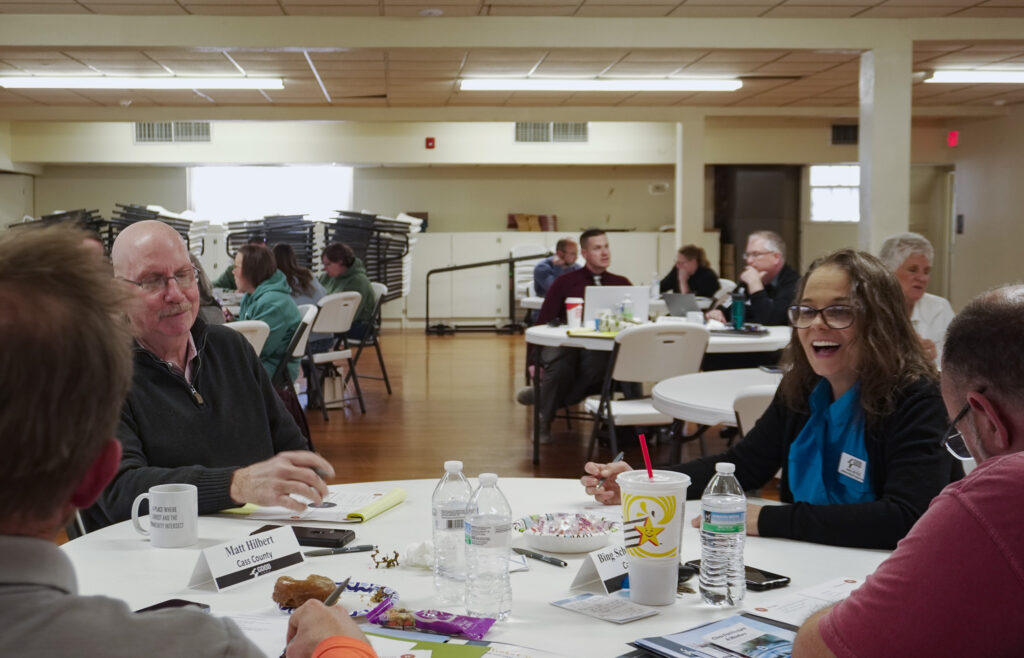 Chapter orientation attendees participate in a small-group conversation while sitting at a table.