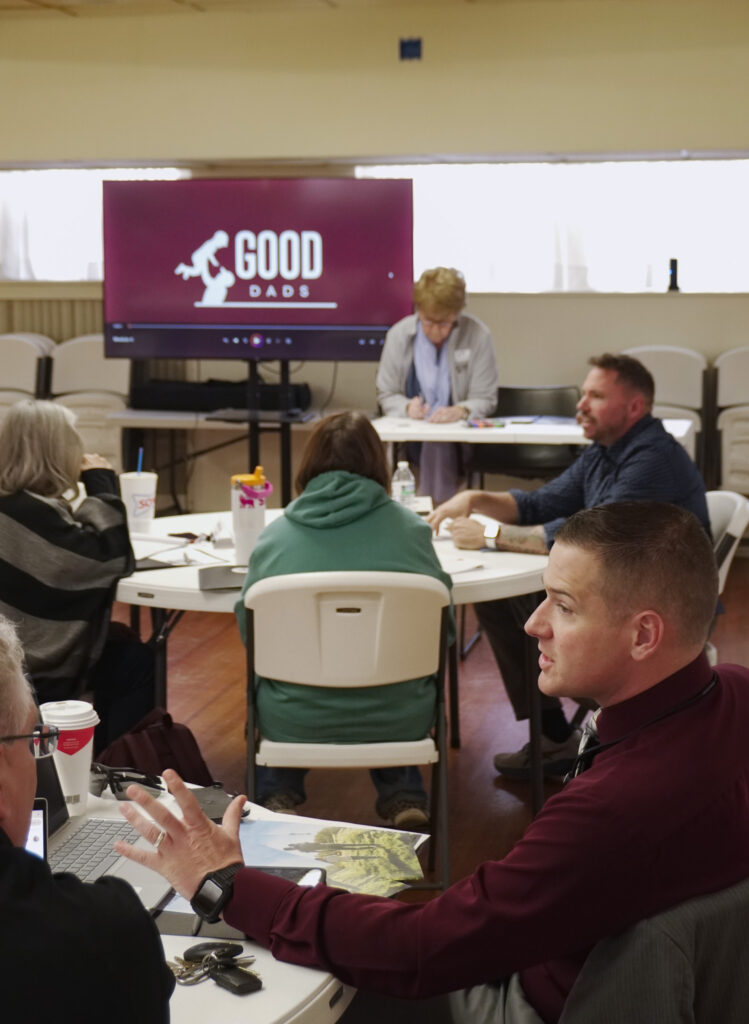 Chapter leaders engage in conversation with one another in small groups at their tables during chapter orientation.