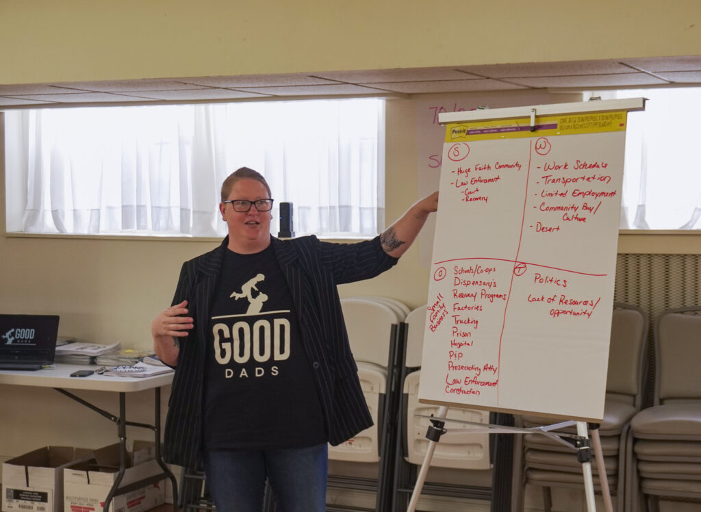 Texas County chapter leader Amanda Kane presents her group's SWOT analysis on chart paper at the front of the room.