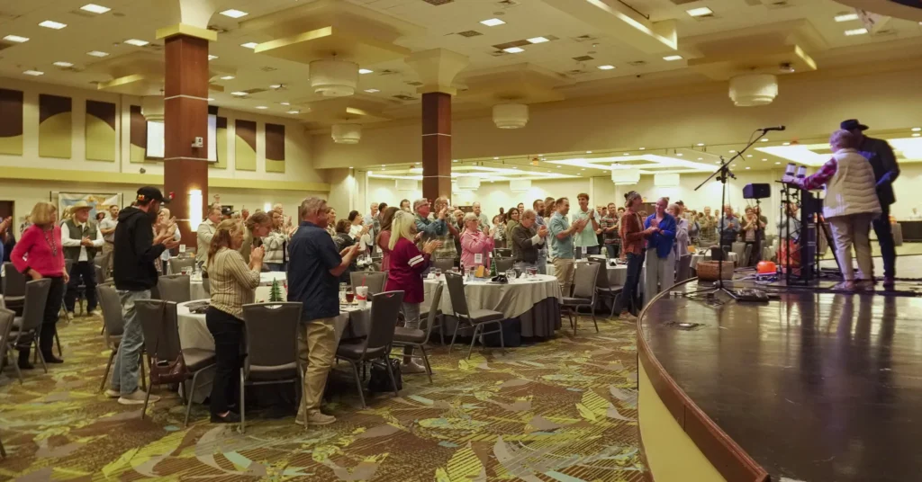 Fundraising dinner guests give a standing ovation for Dr. Jennifer L. Baker, Good Dads founder and director, as she receives a plaque recognizing her dedication to the nonprofit.