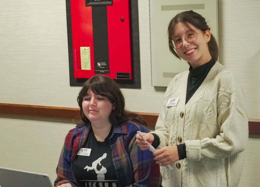 Good Dads staff members Katie Sammons (right) and Dora Gilreath man the merchandise table in the event's lobby