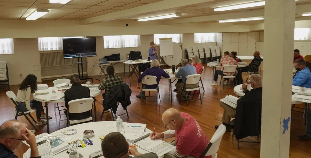 Good Dads founder and director Dr. Jennifer L. Baker stands at the front of the classroom to speak to the group of Good Dads 2.0 facilitators during the first day of fall Training Camp in November 2025.