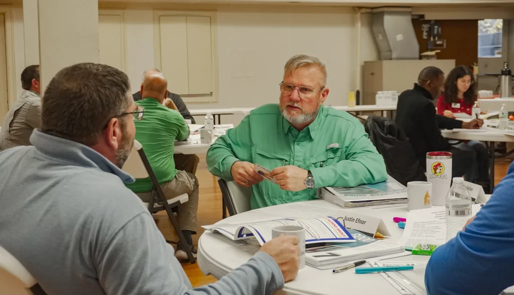 Attendees of Good Dads' fall 2025 training camp sit in groups at round tables in a classroom at the Downtown Church in Springfield, MO.