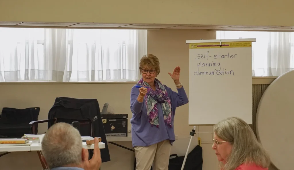 Good Dads founder and director Dr. Jennifer L. Baker stands at the front of the classroom and answers a question from a participant during Good Dads 2.0 facilitator Training Camp in November 2025.