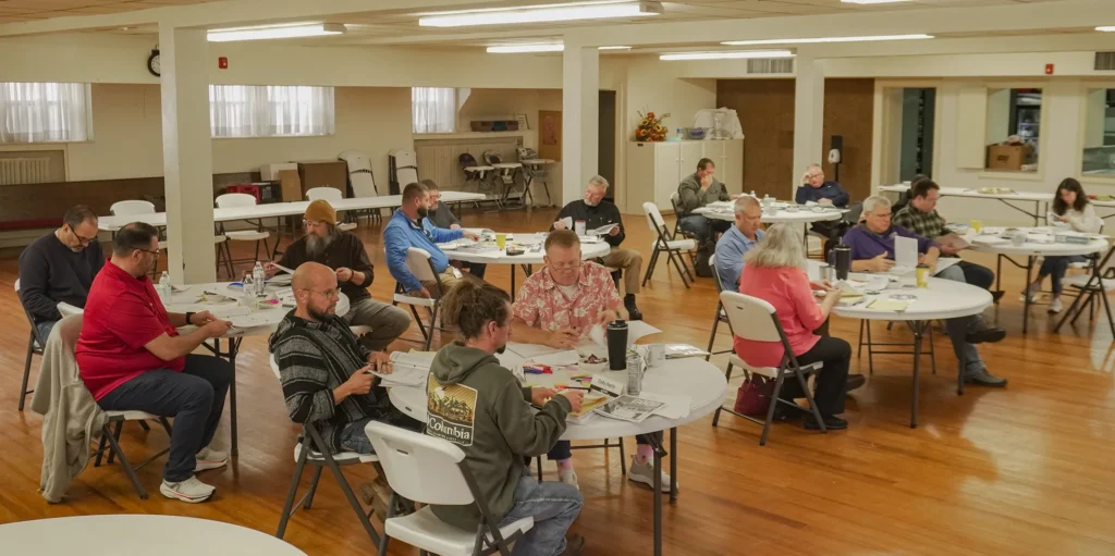 Attendees of Good Dads' fall 2025 training camp sit in groups at round tables in a classroom at the Downtown Church in Springfield, MO.