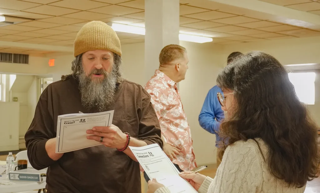 Two soon-to-be facilitators, a man and a woman, introduce themselves to one another at the beginning of Good Dads 2.0 training camp in November 2025 in Springfield, MO.