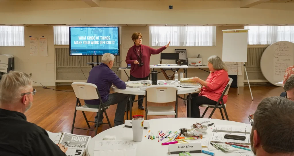 Good Dads Master Facilitator Sally Herman stands at the front of the classroom to speak to the group of Good Dads 2.0 facilitators during the first day of fall Training Camp in November 2025.