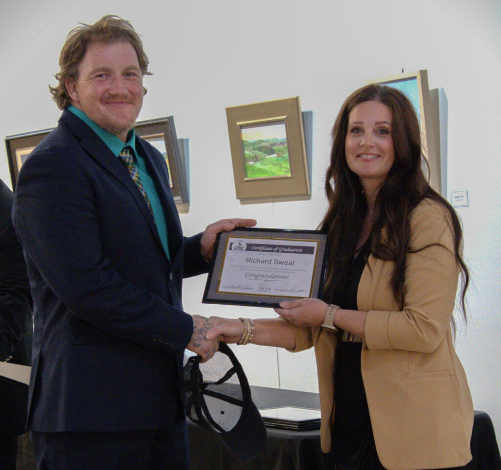 Ricky Sweat is presented with a New Pathways graduation certificate