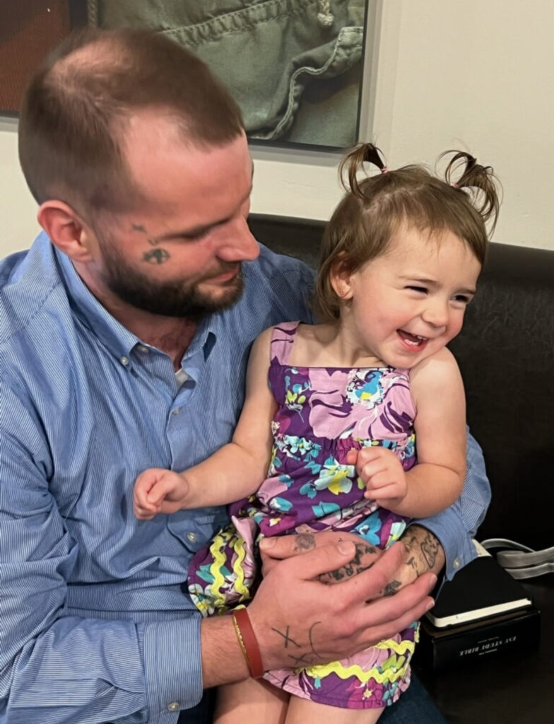 Ryan Warren holds his laughing 2-year-old daughter, Samsara.