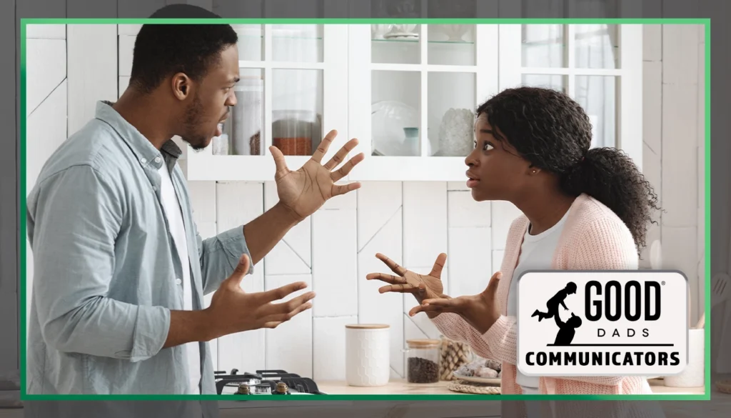 Good Dads Communicators: A couple stands facing each other in a kitchen, having a disagreement