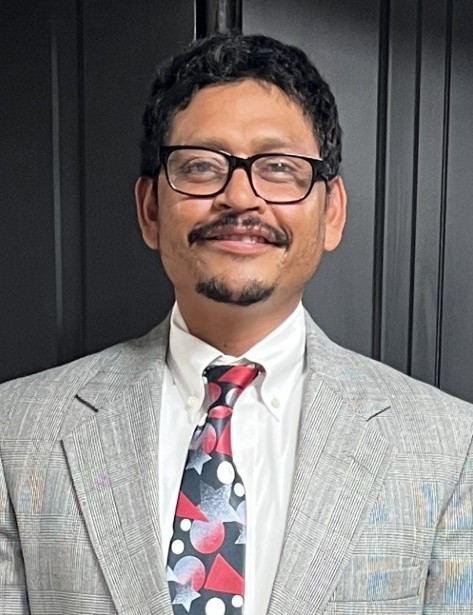 José Torres headshot, wearing his graduation suit.