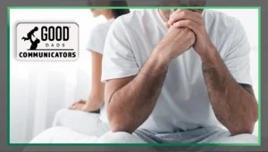 Good Dads Communicators: A man wearing white with clasped hands faces the viewer, his face out of frame. A woman sits back to back to him, her face out of frame as well