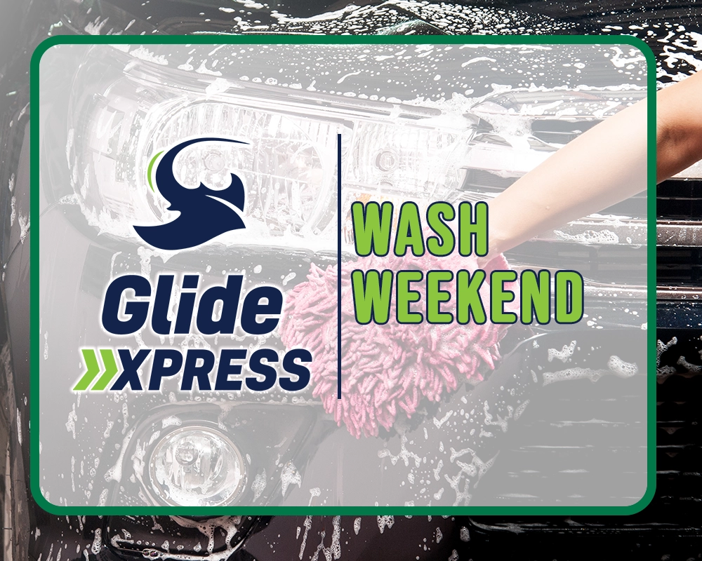 A hand uses sudsy water to scrub the front of a black car; in front of the photo is the Glide Xpress logo and the words "Wash Weekend"