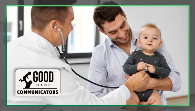 Good Dads Communicators: A smiling father holds his young son at a doctor's office. A doctor stands by holding a stethoscope out to the young child's chest
