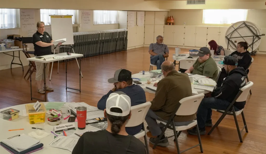 Good Dads' Director of Training & Education Rhonda Andersen, addresses the room of facilitators at the Downtown Church in September 2026 during Training Camp.