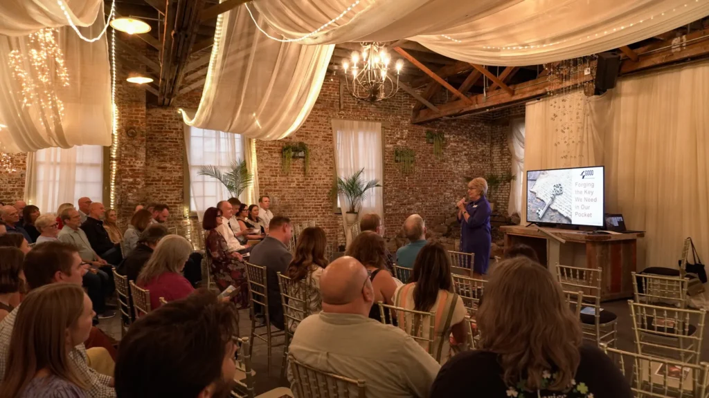 Good Dads Founder and executive director Dr. Jennifer L. Baker, addresses the room full of guests facing the front, at the start of her PowerPoint presentation during the September 2026 fall fundraising dinner for Good Dads.