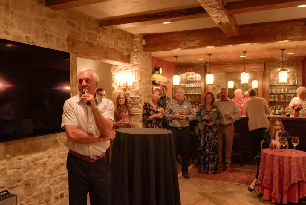 Good Dads executive board member Jim Towery introduces the room to Dr. Jennifer L. Baker, during the evening program at an evening reception in October 2026.