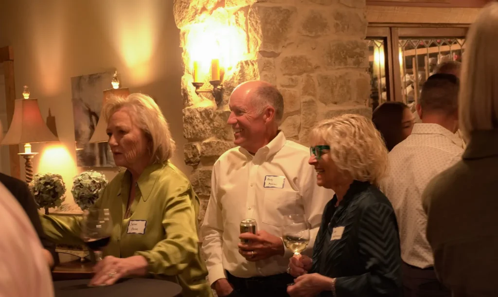 Good Dads supporters and board members mingle at an evening reception to celebrate the nonprofit's outcomes, at the home of a Good Dads board member, in October 2026.